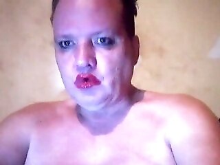 Perverted Feminized Male With Bright Crimson Lip Liner And Bold Makeup Shows Off Pierced Nips